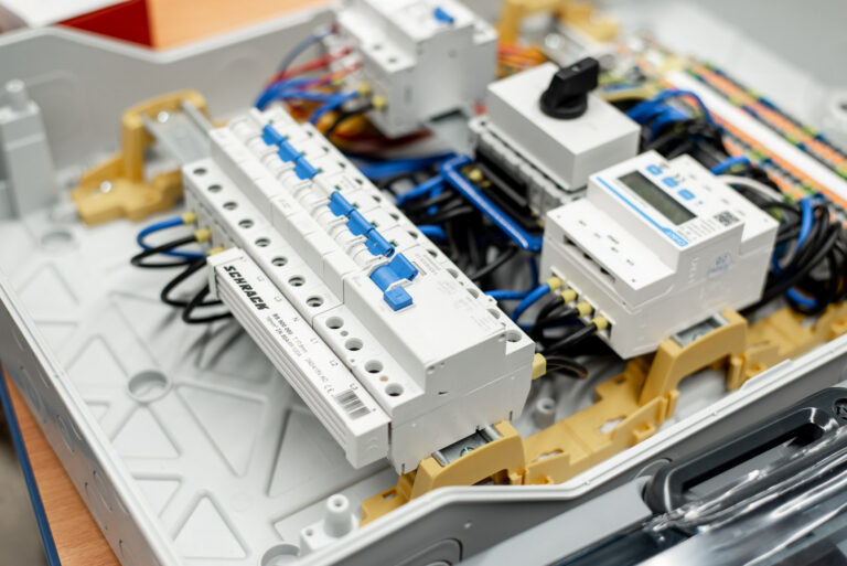 Geöffnete PV-Box: links SCHRACK Schalter mit blauen Hebeln, rechts Digitalmodul und schwarzer Drehschalter.